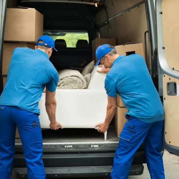 Two Male Workers Unloading White Sofa — Removals & General Freight in Port Macquarie, NSW